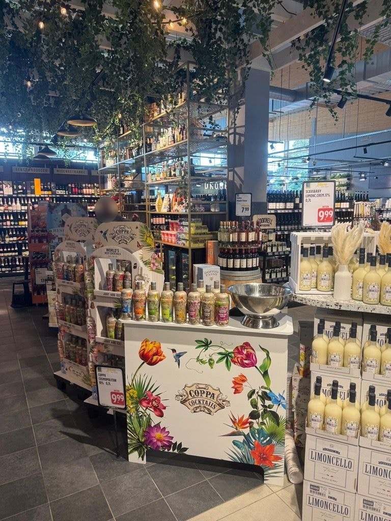 Cocktail-Display mit Verkaufstheke in der Weinabteilung eines Marktes