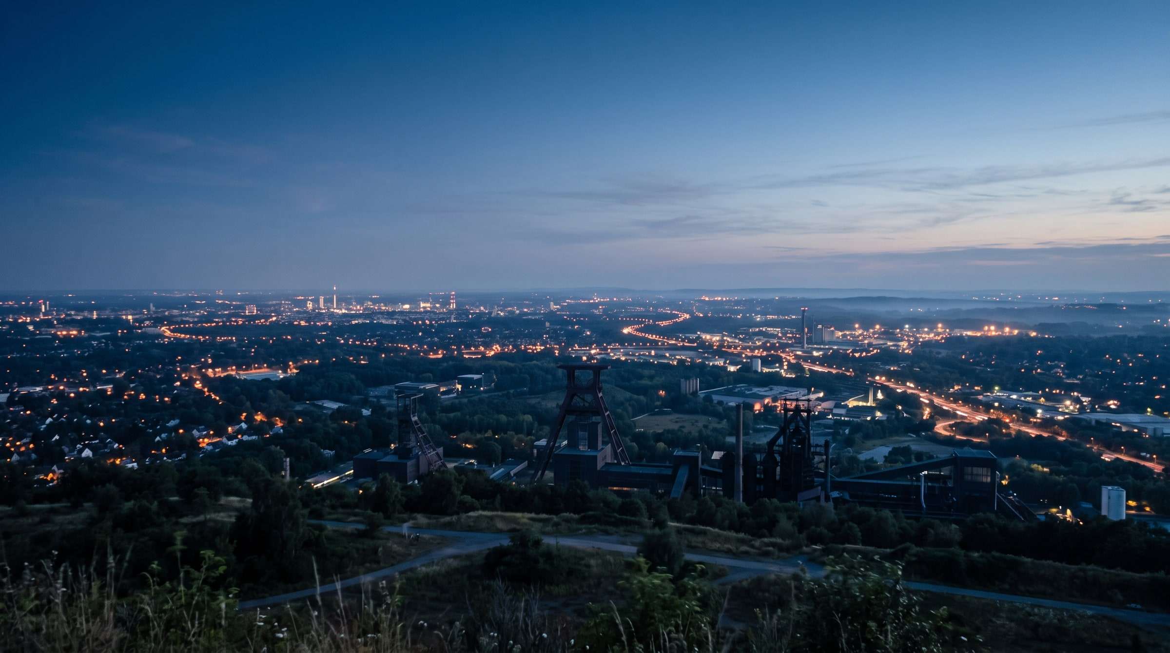 Das Ruhrgebiet in der blauen Stunde mit Fördertürmen und den Lichtern der Städte