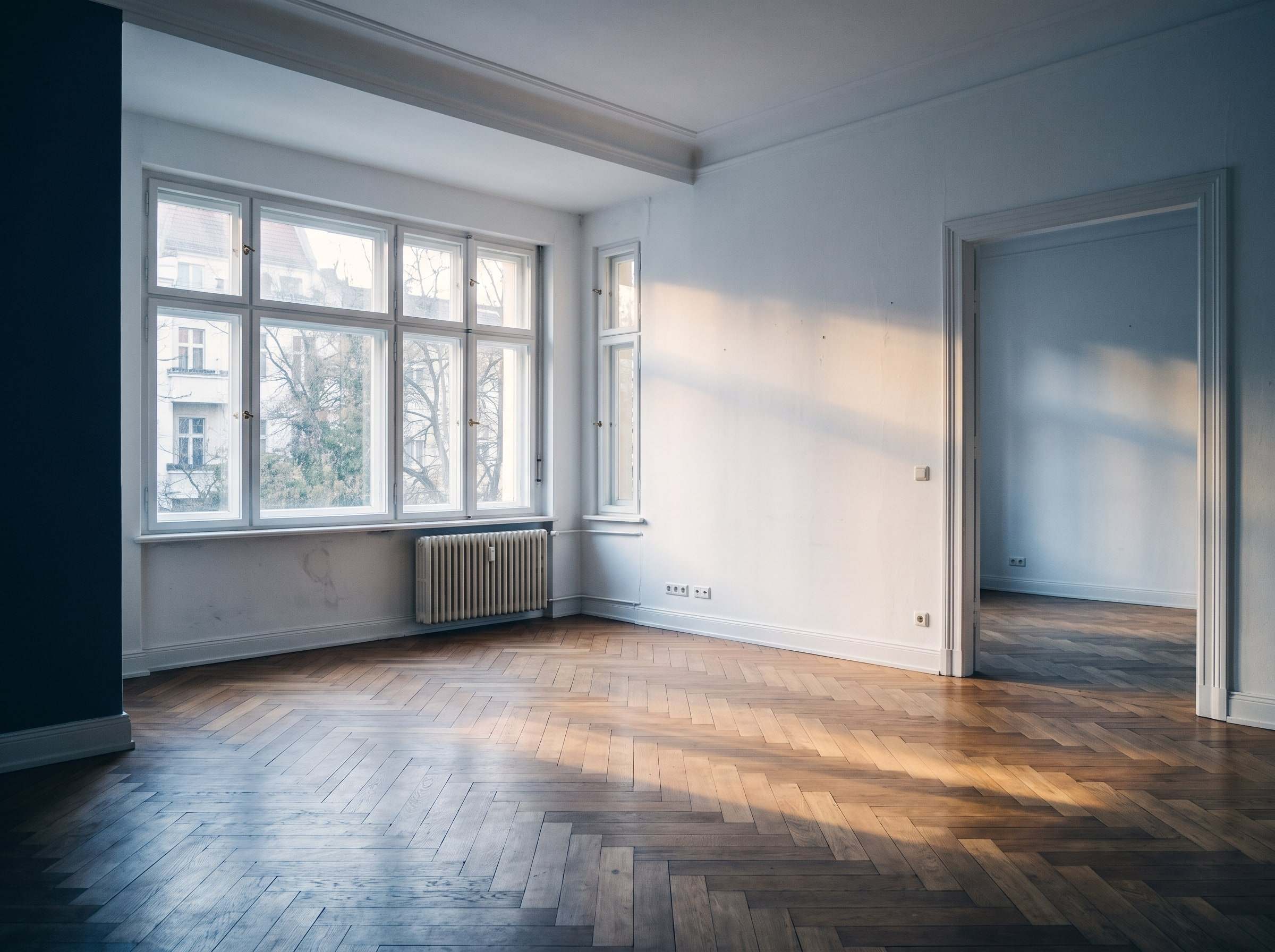 Helle, leere Altbauwohnung mit Fischgrätparkett und großen Fenstern